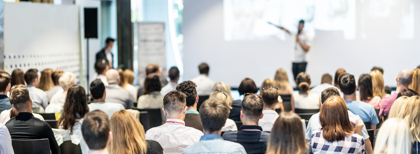 Attendees view a session at a conference.