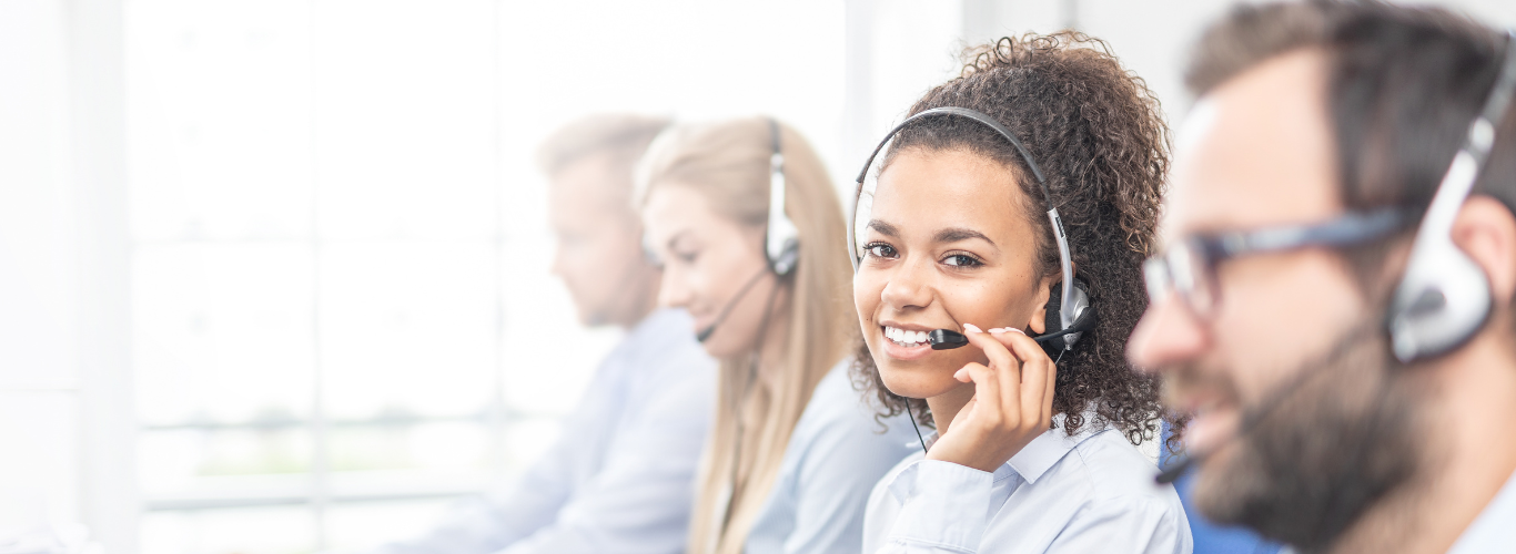 Woman wearing headset looks towards camera.
