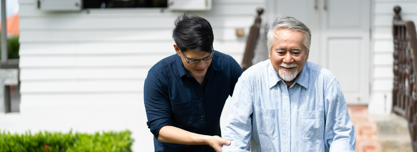 Caregiver helping older man use walker